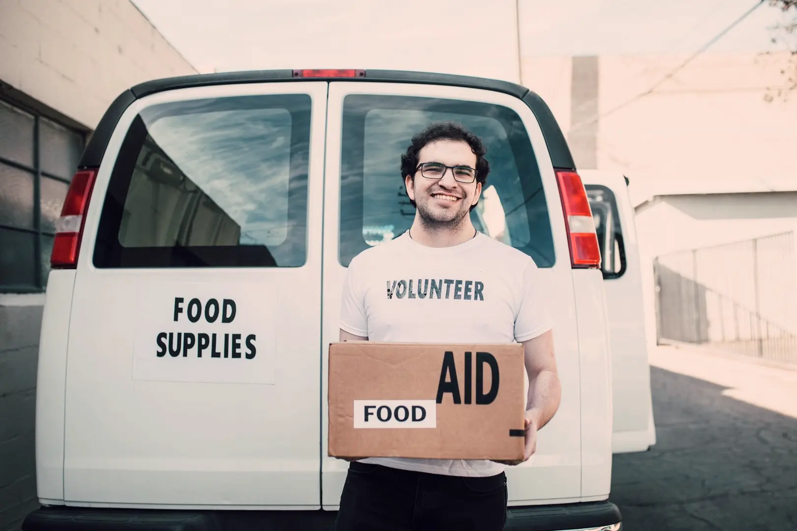 Marcus holding an aid box at the back of the van